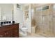 This cozy bathroom features a glass enclosed shower, built-in storage, and a dark vanity with marble countertop at 238 Michelangelo Way, Cary, NC 27518