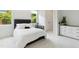 This bedroom features a black tufted headboard, two windows, a small table, and a neutral color palette at 238 Michelangelo Way, Cary, NC 27518