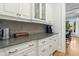 Butler's pantry with granite countertops, white cabinetry, and a view into the dining room at 238 Michelangelo Way, Cary, NC 27518