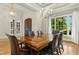Dining room featuring hardwood floors, chandelier, large window, and seating for six at 238 Michelangelo Way, Cary, NC 27518