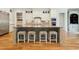 Kitchen island with granite countertops, seating for four, and hardwood floors at 238 Michelangelo Way, Cary, NC 27518