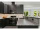 Kitchen features modern dark cabinets, granite countertops, stainless steel appliances, and mosaic backsplash at 238 Michelangelo Way, Cary, NC 27518