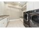 This laundry room features black front load machines, granite counters, a drying rack, and built in bench at 238 Michelangelo Way, Cary, NC 27518