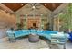 Covered patio features brick walls, wood ceiling, ceiling fan, stone flooring and large blue sectional sofa at 238 Michelangelo Way, Cary, NC 27518