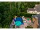 An elevated view of the pool with an umbrella, chairs, patio, and lush greenery at 238 Michelangelo Way, Cary, NC 27518