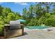 Outdoor kitchen with professional Lynx grill overlooking a sparkling pool and lush landscaping at 238 Michelangelo Way, Cary, NC 27518