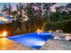 Scenic outdoor pool at dusk with glowing lights, a fire pit, and a comfortable seating area at 238 Michelangelo Way, Cary, NC 27518