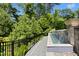 Outdoor infinity pool with waterfall feature surrounded by well-maintained landscaping and trees at 238 Michelangelo Way, Cary, NC 27518