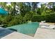 Infinity pool overlooking wooded backyard with lounge chairs and tranquil waterfall feature at 238 Michelangelo Way, Cary, NC 27518