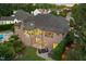 An aerial view captures the brick home's backyard, with a patio, lush landscaping, and mature trees at 238 Michelangelo Way, Cary, NC 27518