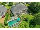 An aerial shot captures the backyard of the brick home, featuring a pool, patio, lush lawn, and landscaping at 238 Michelangelo Way, Cary, NC 27518