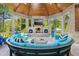 This furnished sunroom includes a semi circle shaped couch, a stone fireplace, and tons of natural light at 238 Michelangelo Way, Cary, NC 27518