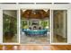 This furnished sunroom features a semi circle shaped couch, stone fireplace, and plenty of natural light at 238 Michelangelo Way, Cary, NC 27518