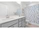 Well-lit bathroom features a double vanity, a toilet, and a tub with a decorative shower curtain at 279 Edge Of Auburn Blvd, Raleigh, NC 27610