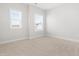 A sunlit bedroom with two windows, neutral carpet and walls creating a serene atmosphere at 279 Edge Of Auburn Blvd, Raleigh, NC 27610