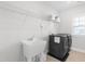Bright laundry room with utility sink, overhead shelving, and modern washer and dryer units at 279 Edge Of Auburn Blvd, Raleigh, NC 27610