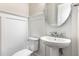 Elegant half-bathroom featuring a pedestal sink, stylish mirror, and white wainscoting at 3109 Stockdale Dr, Raleigh, NC 27609