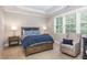 Serene bedroom with tray ceiling, upholstered headboard, and sitting area by a bright window at 3109 Stockdale Dr, Raleigh, NC 27609
