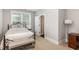 Simple bedroom with a wrought iron bed, a window and a glimpse into the adjacent bathroom at 3109 Stockdale Dr, Raleigh, NC 27609