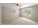 Bedroom showing tan carpet, a ceiling fan, a painting, and a window with natural light at 313 Glen Echo Ln # J, Cary, NC 27518