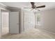 Bedroom featuring neutral carpet, a ceiling fan, a window, and double doors to a closet at 313 Glen Echo Ln # J, Cary, NC 27518
