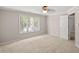 Bedroom view showing tan carpet, a window with blinds, and a door leading to the bathroom at 313 Glen Echo Ln # J, Cary, NC 27518