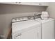 This laundry room features a white washer and dryer with overhead cabinets for convenient storage at 313 Glen Echo Ln # J, Cary, NC 27518