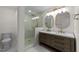 Modern bathroom with a glass enclosed shower, double vanity with stone countertop and contemporary lighting at 314 Wrenn St, Apex, NC 27502