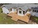 Aerial view of a spacious wooden deck adjoining a white brick home with lush greenery in the yard at 314 Wrenn St, Apex, NC 27502