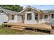 White brick home featuring a large wooden deck with steps, complemented by a neatly maintained lawn at 314 Wrenn St, Apex, NC 27502