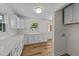 Well-lit kitchen boasts white cabinets, quartz counters, new appliances, and modern wood-look flooring at 314 Wrenn St, Apex, NC 27502
