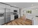 Modern kitchen features stainless appliances, quartz countertops, white cabinets with gold hardware, and wood-look flooring at 314 Wrenn St, Apex, NC 27502