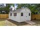 A white shed with black shutters and flower boxes sits in a backyard with a wooden ramp at 314 Wrenn St, Apex, NC 27502