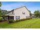 View of home's rear exterior with an expansive lawn, manicured shrubs and a screened porch at 3141 Rapid Falls Rd, Cary, NC 27519