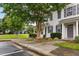 Beautifully landscaped townhome exterior with lush greenery, inviting entrance, and sidewalk at 3141 Rapid Falls Rd, Cary, NC 27519