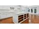 Well-lit kitchen with white cabinets, center island, and hardwood floors at 3141 Rapid Falls Rd, Cary, NC 27519