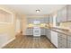 Well-lit kitchen featuring gray cabinets, modern appliances, and wood-look flooring at 408 N Stewart St, Clayton, NC 27520