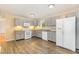 Functional kitchen with gray cabinets, white appliances, and wood-look flooring at 408 N Stewart St, Clayton, NC 27520
