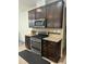 Kitchen with stainless steel stove, microwave, granite counters, and dark wood cabinets at 425 Liberty Hill, Morrisville, NC 27560