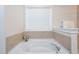 A relaxing tub beneath a window creates a bright space in this bathroom at 453 Granite Saddle Dr, Rolesville, NC 27571