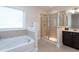 Bright bathroom with a soaking tub, glass shower, and a large window providing natural light at 453 Granite Saddle Dr, Rolesville, NC 27571