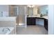 Luxurious bathroom featuring a soaking tub, glass-enclosed shower, and elegant vanity with ample counter space at 453 Granite Saddle Dr, Rolesville, NC 27571