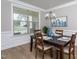 Bright dining room featuring a dark wood table and chairs, modern decor, and ample natural light from a large window at 453 Granite Saddle Dr, Rolesville, NC 27571
