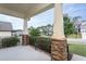 Inviting front porch with stone pillars and iron railing, perfect for enjoying the neighborhood views at 453 Granite Saddle Dr, Rolesville, NC 27571