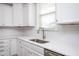 Close-up of a well-lit kitchen, featuring stainless steel sink, white cabinets, and subway tile backsplash at 453 Granite Saddle Dr, Rolesville, NC 27571