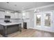 Kitchen with gray island, stainless steel appliances, white cabinets, and door to the outside deck at 453 Granite Saddle Dr, Rolesville, NC 27571