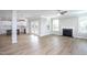 Open-concept living room connected to the kitchen with a fireplace and light-colored wood flooring at 453 Granite Saddle Dr, Rolesville, NC 27571