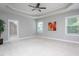Spacious main bedroom with a tray ceiling, carpeted floors, and two bright windows at 453 Granite Saddle Dr, Rolesville, NC 27571