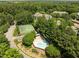 Aerial view of a community swimming pool and tennis court surrounded by trees at 4631 Timbermill Ct # 203, Raleigh, NC 27612