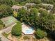 An aerial view of the community pool and tennis courts nestled in a wooded setting at 4631 Timbermill Ct # 203, Raleigh, NC 27612